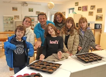Un groupe d'enfants et leur animateur montrent des petits gâteaux
