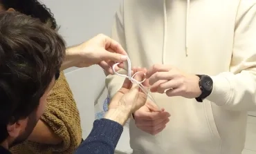 Un animateur aide un participant à effectuer un noeud de huit doublé