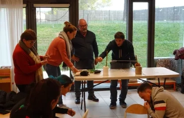 Un animateur montre le noeud tendeur, des adultes sont autour  