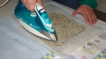 un adulte utilise un fer à repasser sur un bee wrap