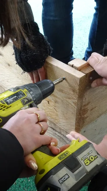 une adulte visse une planche en bois