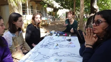 un groupe d'adultes autour d'une table avec un jeu sur le parcours du textile