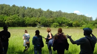 un groupe d'adultes devant un champ