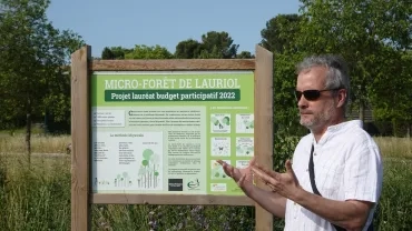 un animateur devant une pancarte d'espace revégétalisé