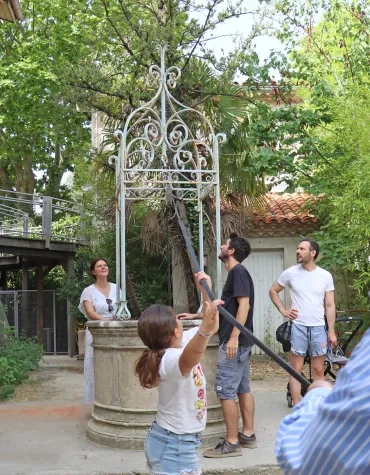 des adultes sont près d'un puits et deux enfants tirent sur une corde