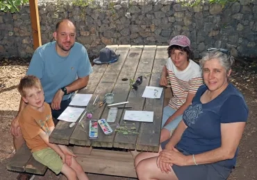 des parents et leurs enfants dessinent sur des tables