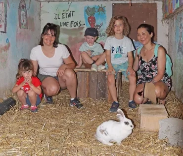 un groupe de mères et leurs enfants posent dans l'enclos des lapins
