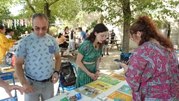 Des animateurs du pôle déchets présentent des affiches à une adulte