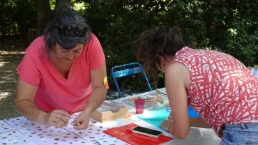 deux adultes remplissent leur nom sur un ticket de tombola  