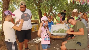 un groupe d'enfants et leur animateur montrent des sachets en tissu