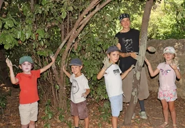 Un groupe d'enfants et leur animatrice montrent leurs mains pleines d'argile