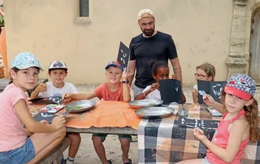 Un groupe d'enfants et leur animateur montrent des livrets