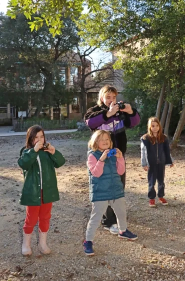 trois enfant et leur animateur prennent des photos