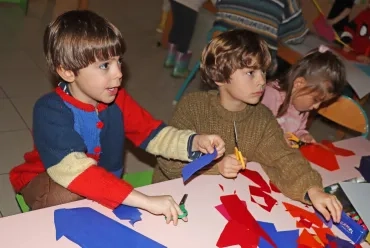 deux enfants découpent du papier coloré