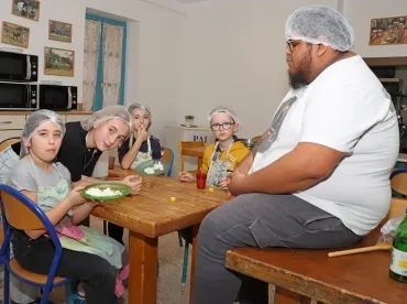 un groupe d'enfants et leur animateur goutent des morceaux de fromage