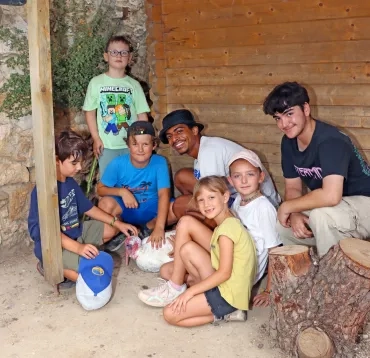 un groupe d'enfants et leurs animateurs caressent un dindon