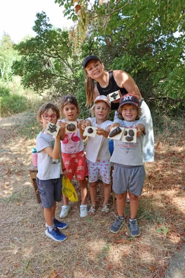 un groupe d'enfants et leur animatrice montrent des crottes