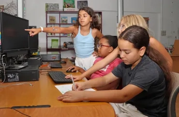 un groupe d'enfants est devant un ordinateur