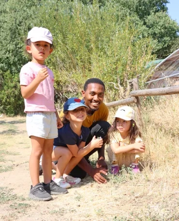un groupe d'enfants et leur animateur posent avec des fleurs
