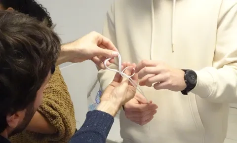 Un animateur aide un participant à effectuer un noeud de huit doublé