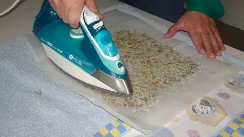 un adulte utilise un fer à repasser sur un bee wrap