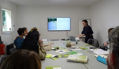 présentation d'une diapositive par un animateur à un groupe d'adultes 