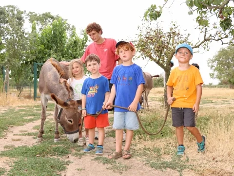 un groupe d'enfants et leur animateur pose avec un âne