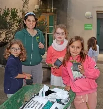 Un groupe d'enfants et leur animatrice mettent du compost dans des godets