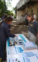 une animatrice présente un outil pédagogique sur la marre à une adulte