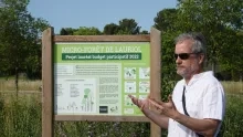 un animateur devant une pancarte d'espace revégétalisé