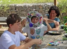 deux enfants et une mère montrent leurs créations en éléments naturels