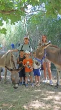 un groupe d'enfants et leur animatrice posent à côté de deux ânes