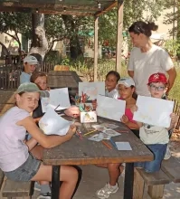 Un groupe d'enfants et leur animatrice montrent des dessins