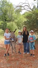 Un groupe d'enfants et leur animatrice posent avec un âne