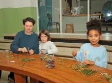 deux enfants et leur animatrice découpent des éléments naturels
