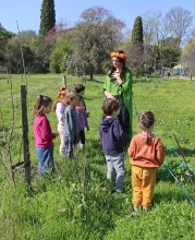 Un groupe d'enfants et leur animatrice déguisée se balade dans le parc