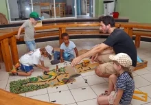un groupe d'enfants et leur animateur sont au sol avec des éléments de maquette