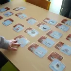 Des cartes d'un jeu pédagogique sur les déchets, éparpillées sur la table 