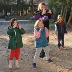 trois enfant et leur animateur prennent des photos