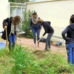 Photo de prsonnes en train de travailler la terre dans un jardin