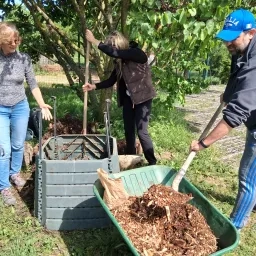 Un participant rajoute dans le compost du broyat, de la matière sèche.